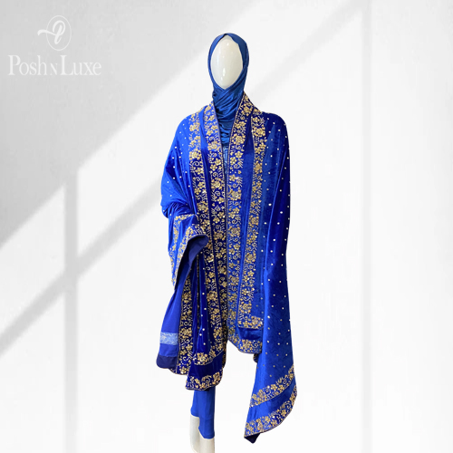woman wearing a blue hand embroidered shawl. The shawl features double embroidered border on all four edges of the velvet shawl.